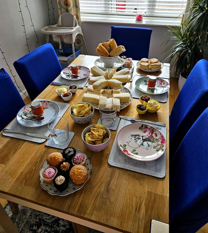 Afternoon tea spread with finger sandwiches, scones, jam and cakes