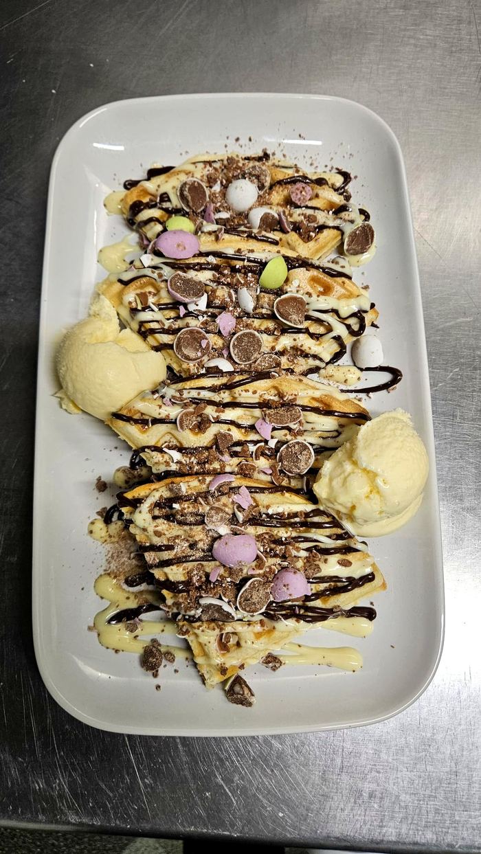 Waffles topped with mini chocolate eggs and chocolate drizzle